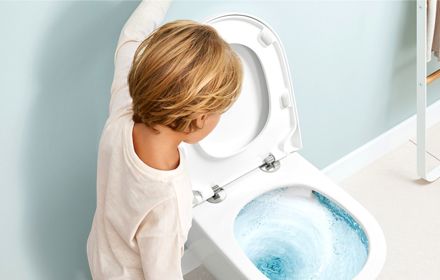 Child Flushing Toilet In Bathroom